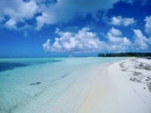 a beach with clear water and blue sky